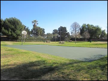 View of basketball courts surrounded by green grass and trees at Hathaway Park