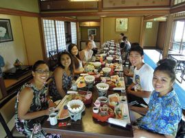 Group of smiling students eating at a Japanese restaurant