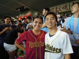 Two students wearing team jerseys at a baseball game in Japan 