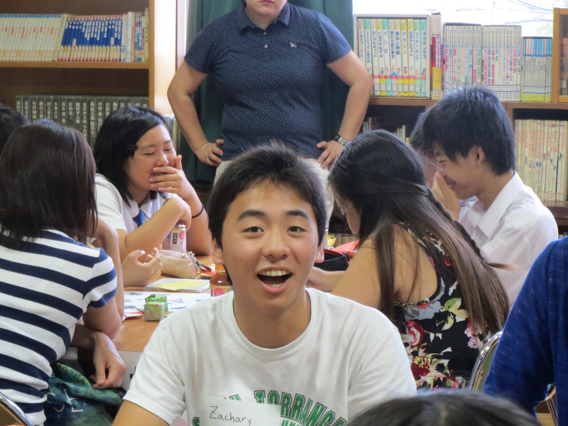 Student smiling in classroom with other students in background
