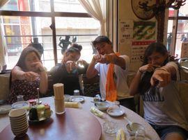 Four students eating at a rotating table Japanese restaurant.