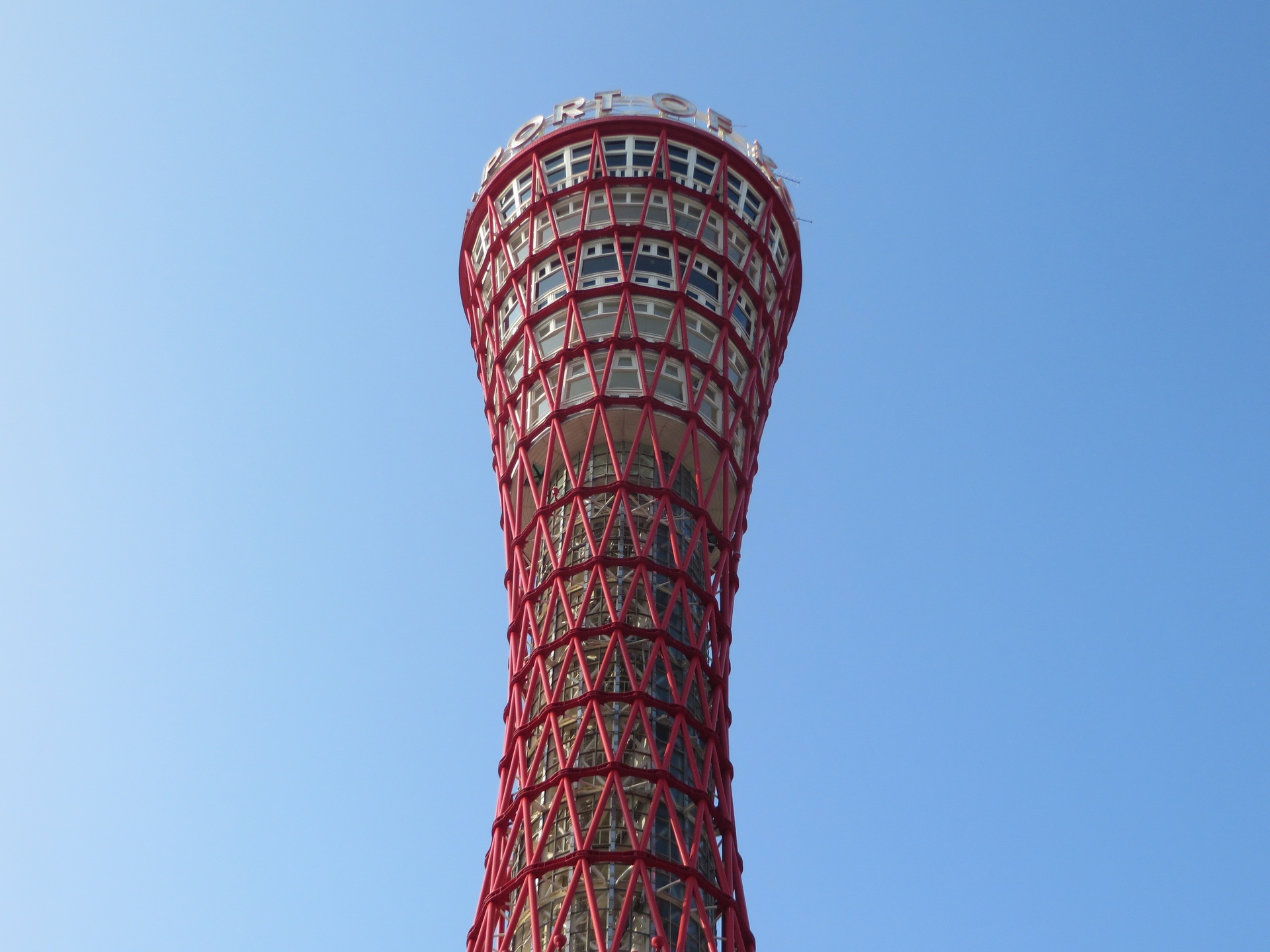 Upward view of the Port of Japan tower with a red net-like exterior