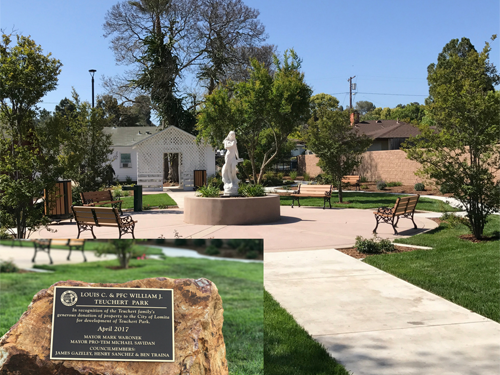 Dedication plaque and view of monument surrounded by path and green grass and trees at Teuchert Park.