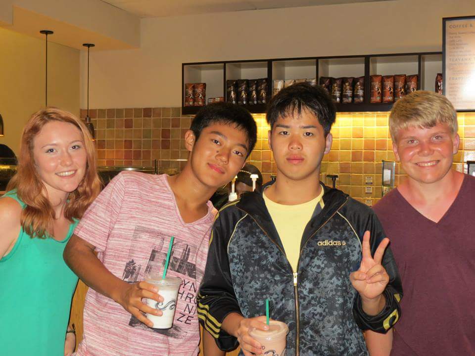 Exchange students smiling with friends at Starbucks